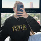 Woman wearing a black crewneck sweatshirt that says 'Sundays are for Taylor' 