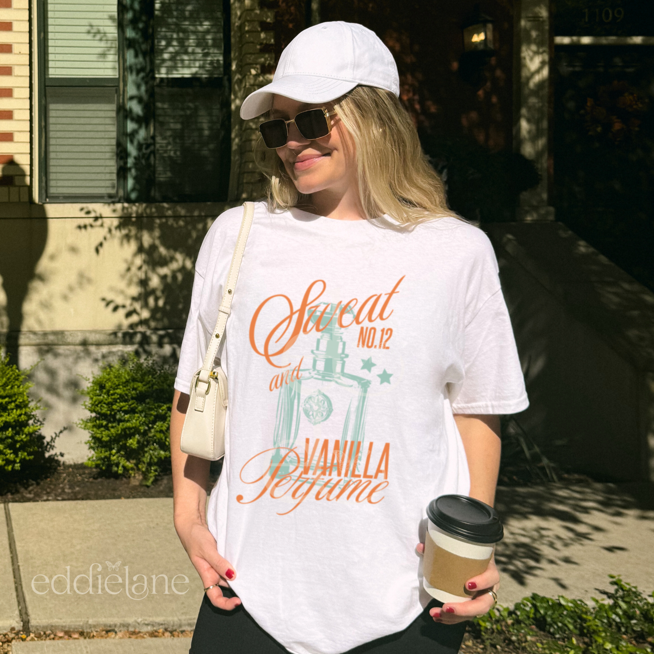 woman wearing a white comfort colors graphic tee with an illustration of a perfume bottle and the words "sweat and vanilla perfume" 