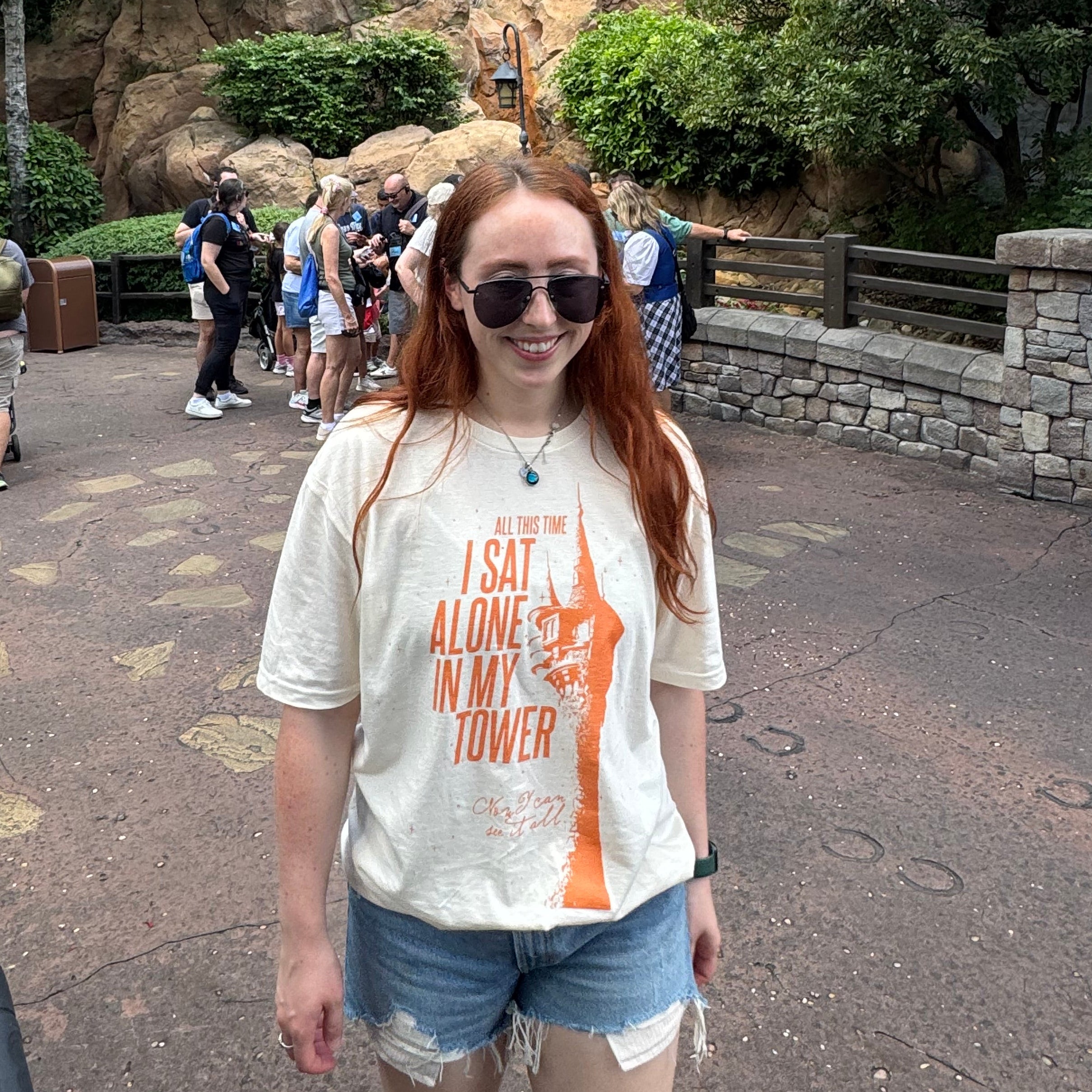 woman wearing an ivory comfort colors shirt with a graphic of a tower and the words "all this time i sat alone in my tower"