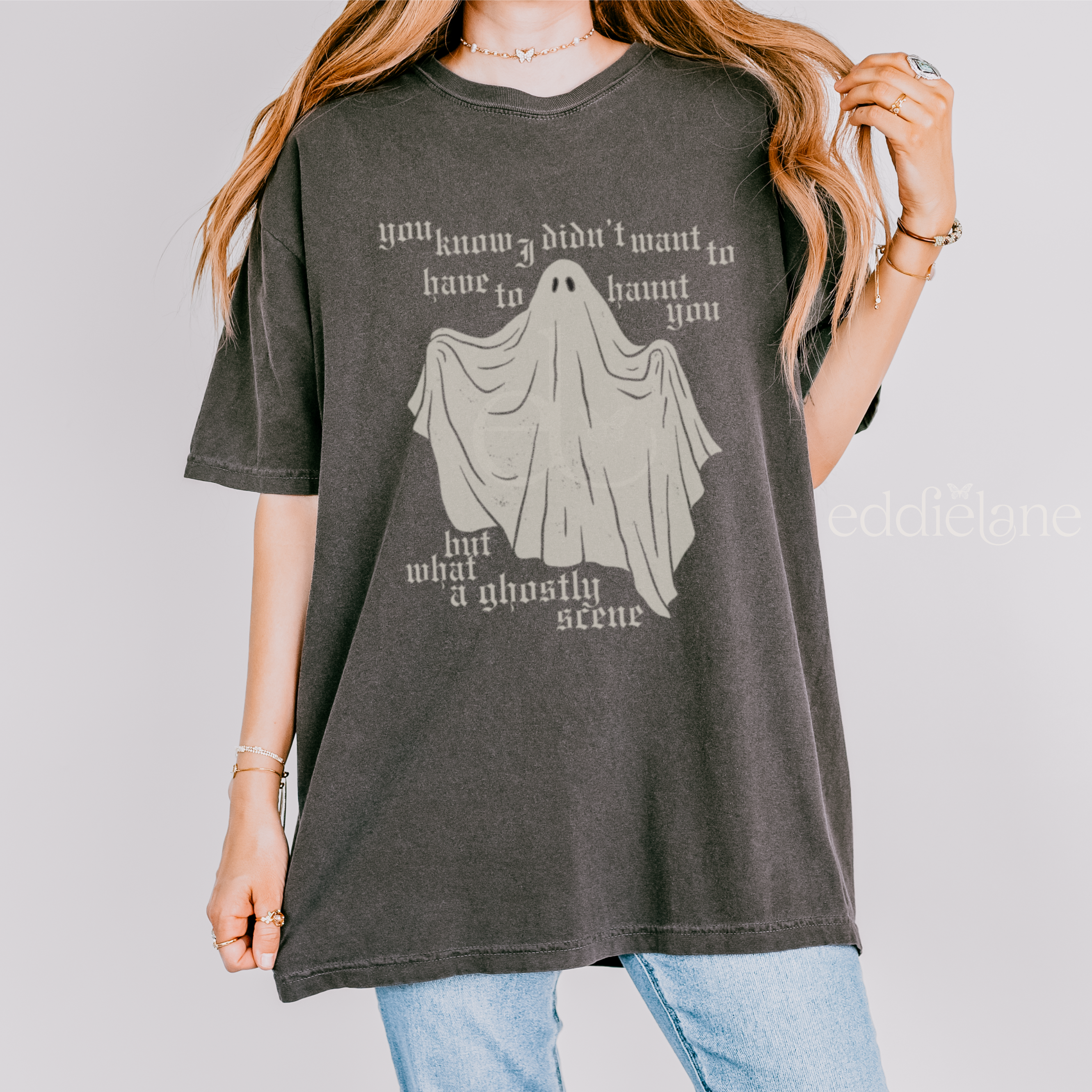 Person wearing a dark gray t-shirt with a ghost graphic and text on a plain background